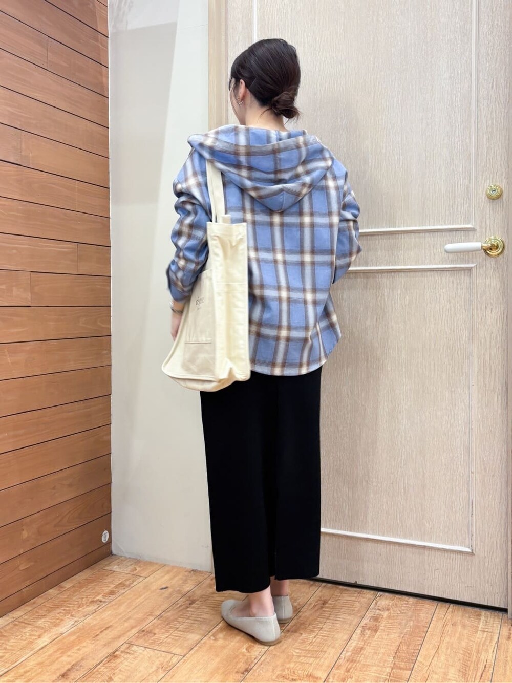 ブラック系のスカート、ブルー系のシャツ/ブラウス、ホワイト系のトートバッグを着用したレディースの春コーディネートの4枚目の写真