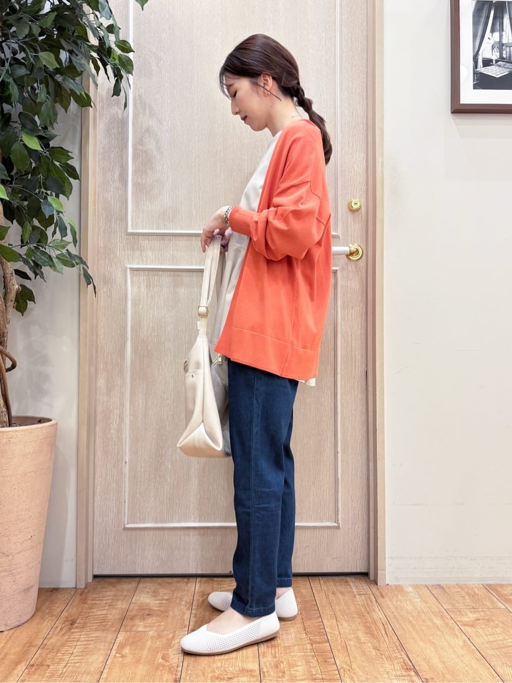 オレンジ系のカーディガン/ボレロ、ベージュ系のTシャツ/カットソー、ブルー系のその他パンツを着用したレディースの春コーディネートの2枚目の写真