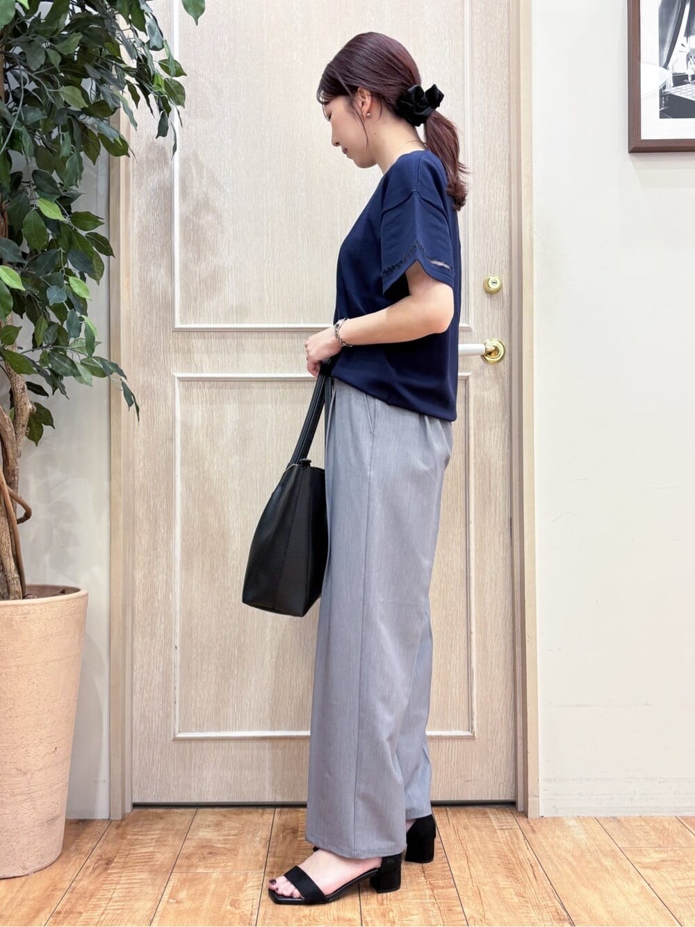 ブルー系のニット/セーター、グレー系のその他パンツ、ブラック系のサンダルを着用したレディースの春コーディネートの2枚目の写真