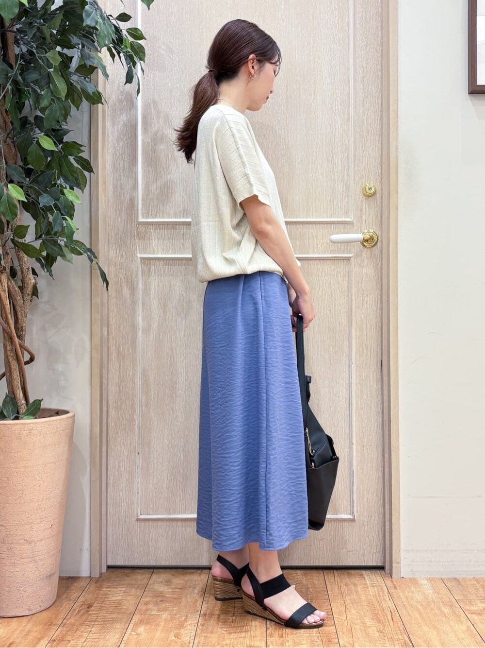 ゴールド系のニット/セーター、ブルー系のその他パンツ、ブラック系のサンダルを着用したレディースの夏コーディネートの2枚目の写真
