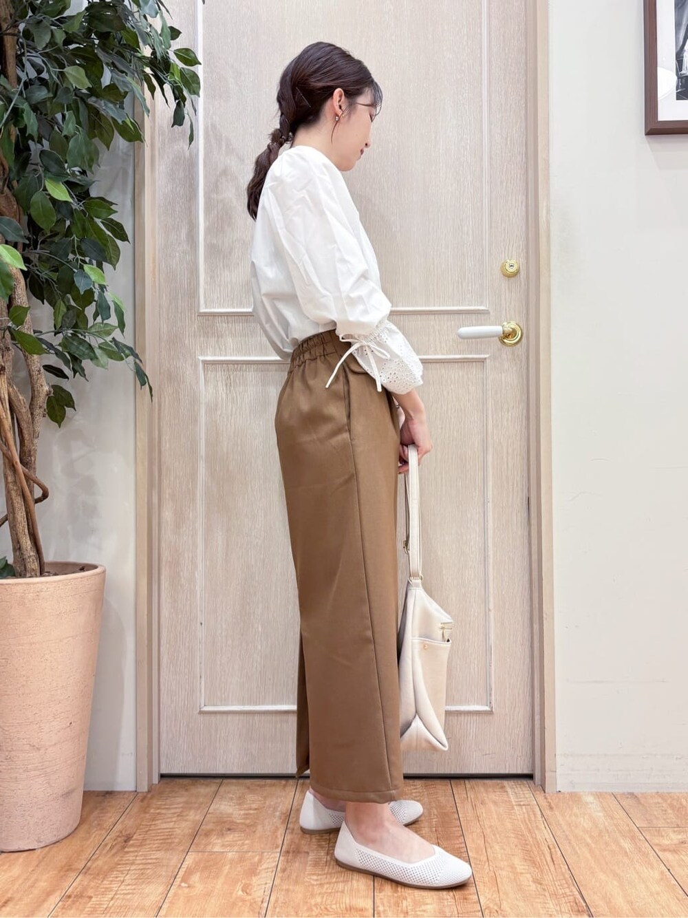 ホワイト系のシャツ/ブラウス、ブラウン系のスカート、ホワイト系のパンプスを着用したレディースの春コーディネートの3枚目の写真