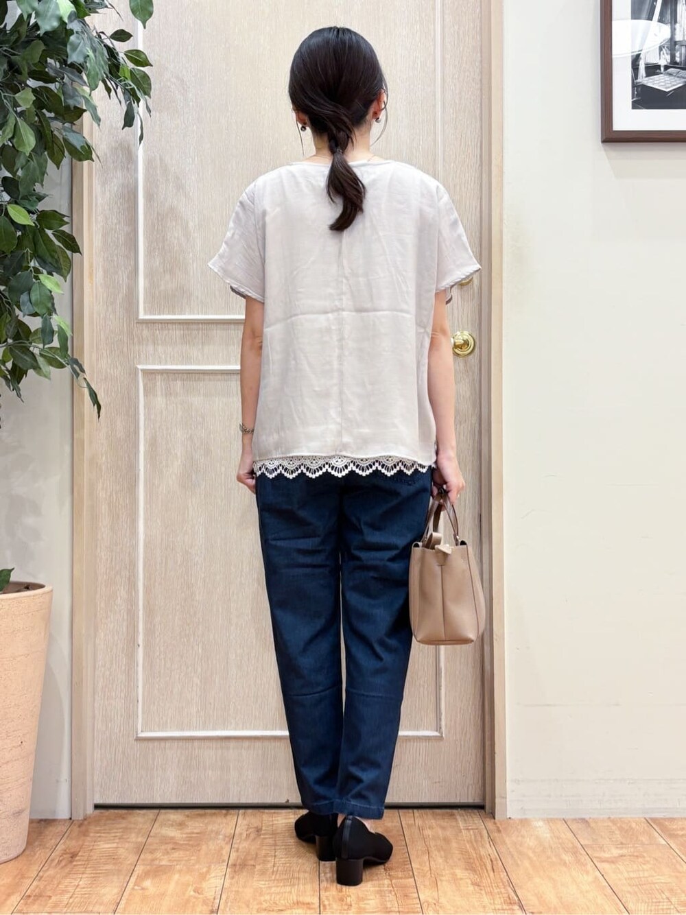 ベージュ系のTシャツ/カットソー、ブルー系のデニムパンツ、ブラック系のパンプスを着用したレディースの夏コーディネートの3枚目の写真