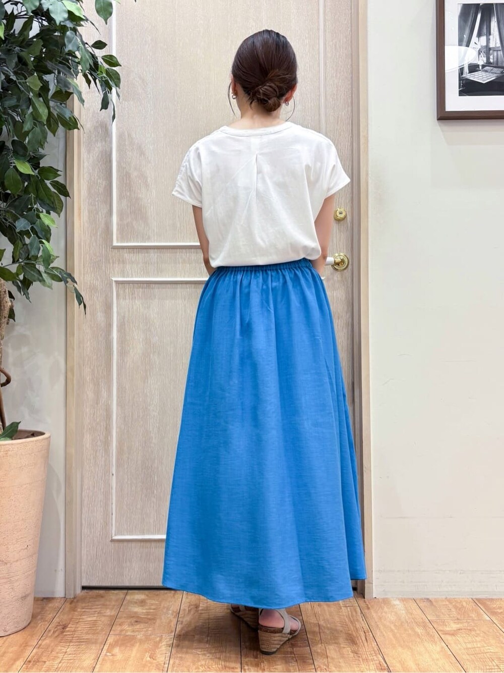 ホワイト系のTシャツ/カットソー、ブルー系のスカート、ブラック系のトートバッグを着用したレディースの夏コーディネートの3枚目の写真