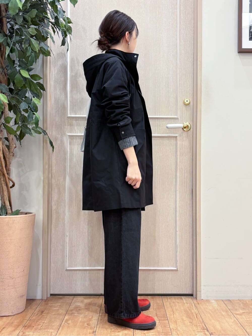 ブラック系のミリタリージャケット、グレー系のニット/セーター、ブラック系のデニムパンツを着用したレディースの冬コーディネートの2枚目の写真