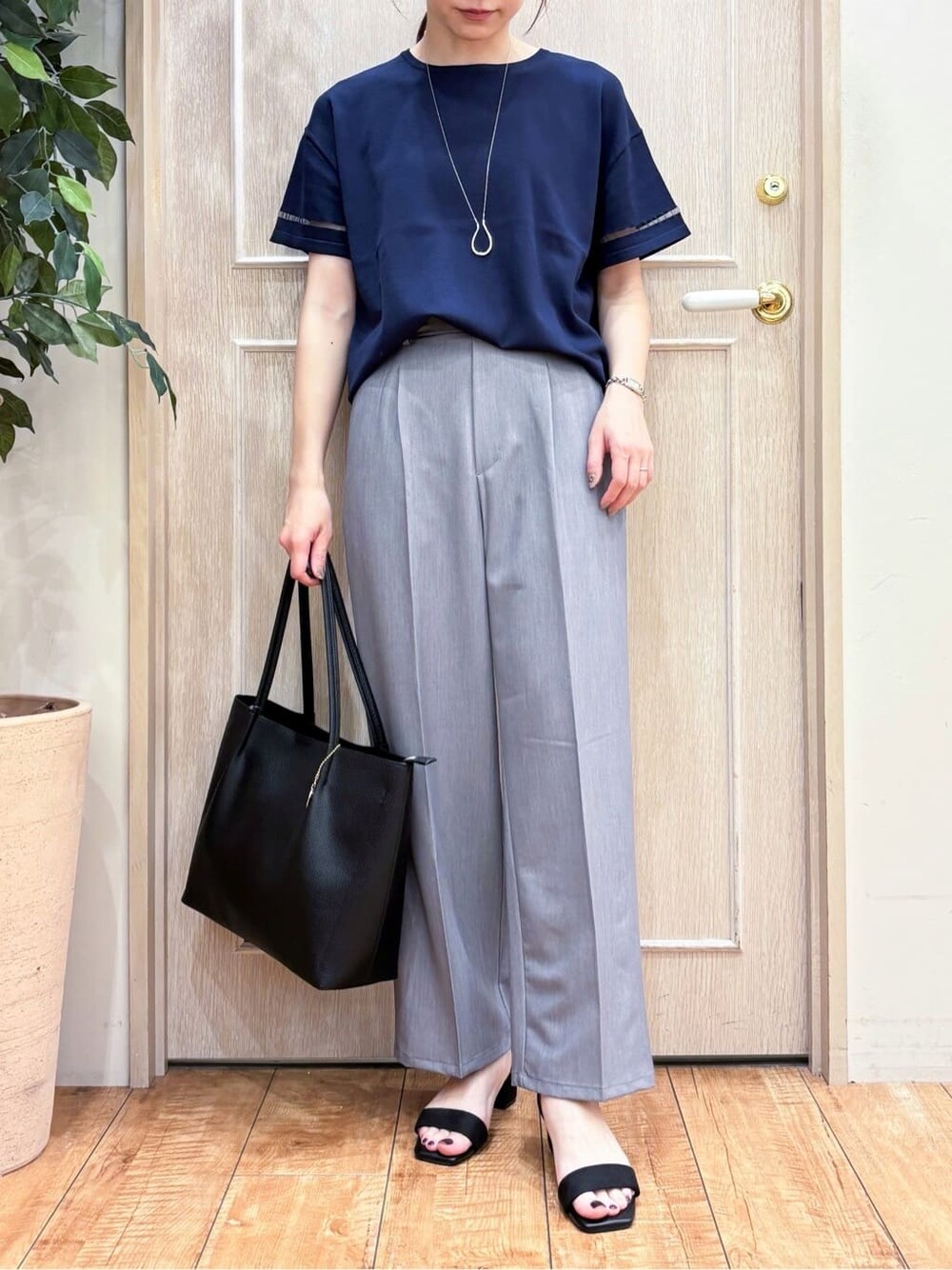 ブルー系のニット/セーター、グレー系のその他パンツ、ブラック系のサンダルを着用したレディースの春コーディネートの4枚目の写真