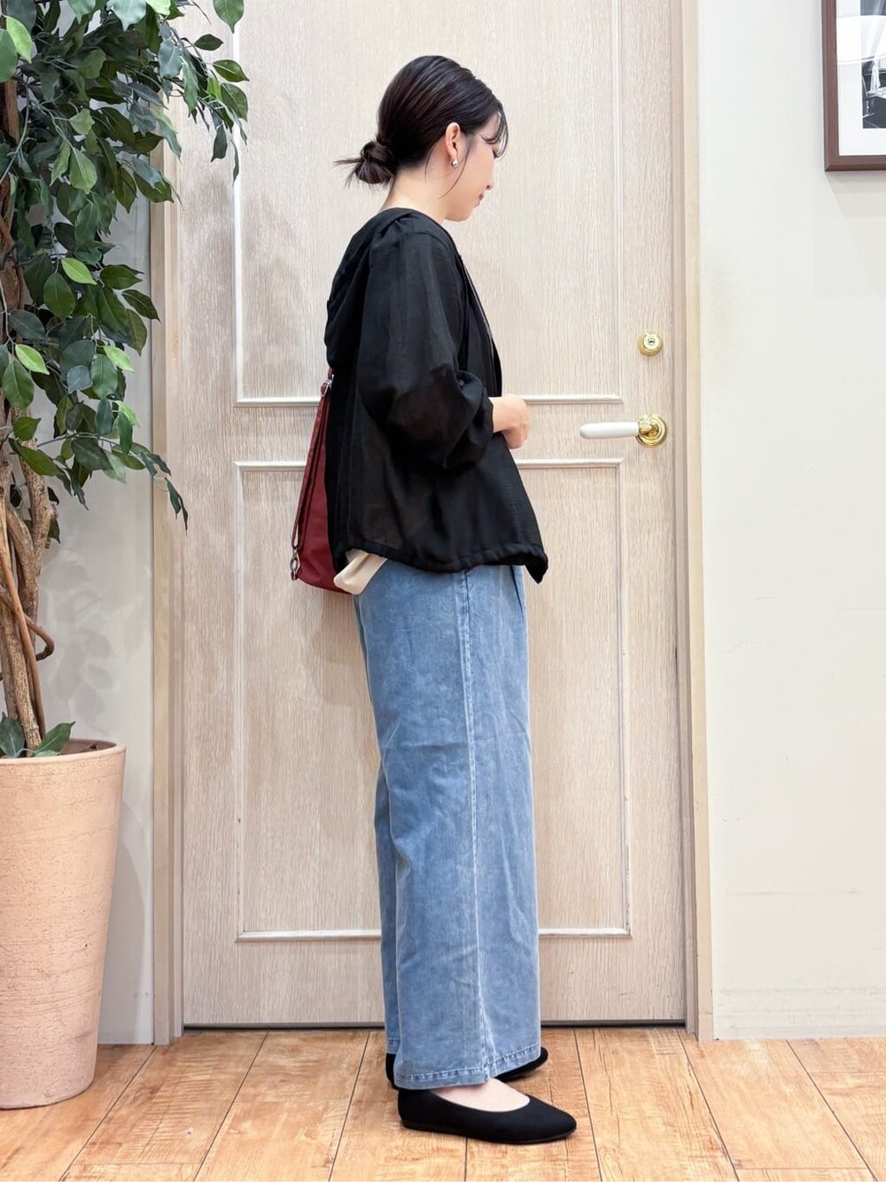 ブラック系のブルゾン、ベージュ系のTシャツ/カットソー、ブルー系のデニムパンツを着用したレディースの秋コーディネートの3枚目の写真