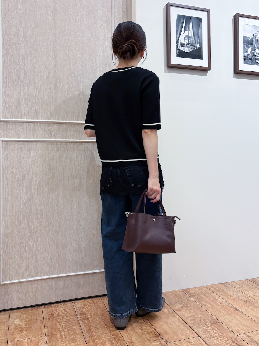 ブラック系のカーディガン/ボレロ、ブラック系のタンクトップ、ブルー系のデニムパンツを着用したレディースの秋コーディネートの4枚目の写真