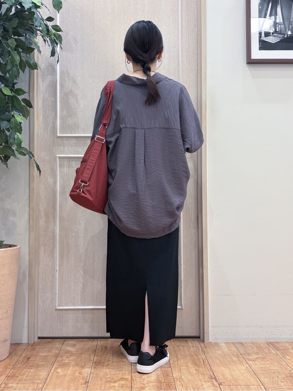 ブラウン系のシャツ/ブラウス、ホワイト系のTシャツ/カットソー、ブラック系のスカートを着用したレディースの秋コーディネートの3枚目の写真