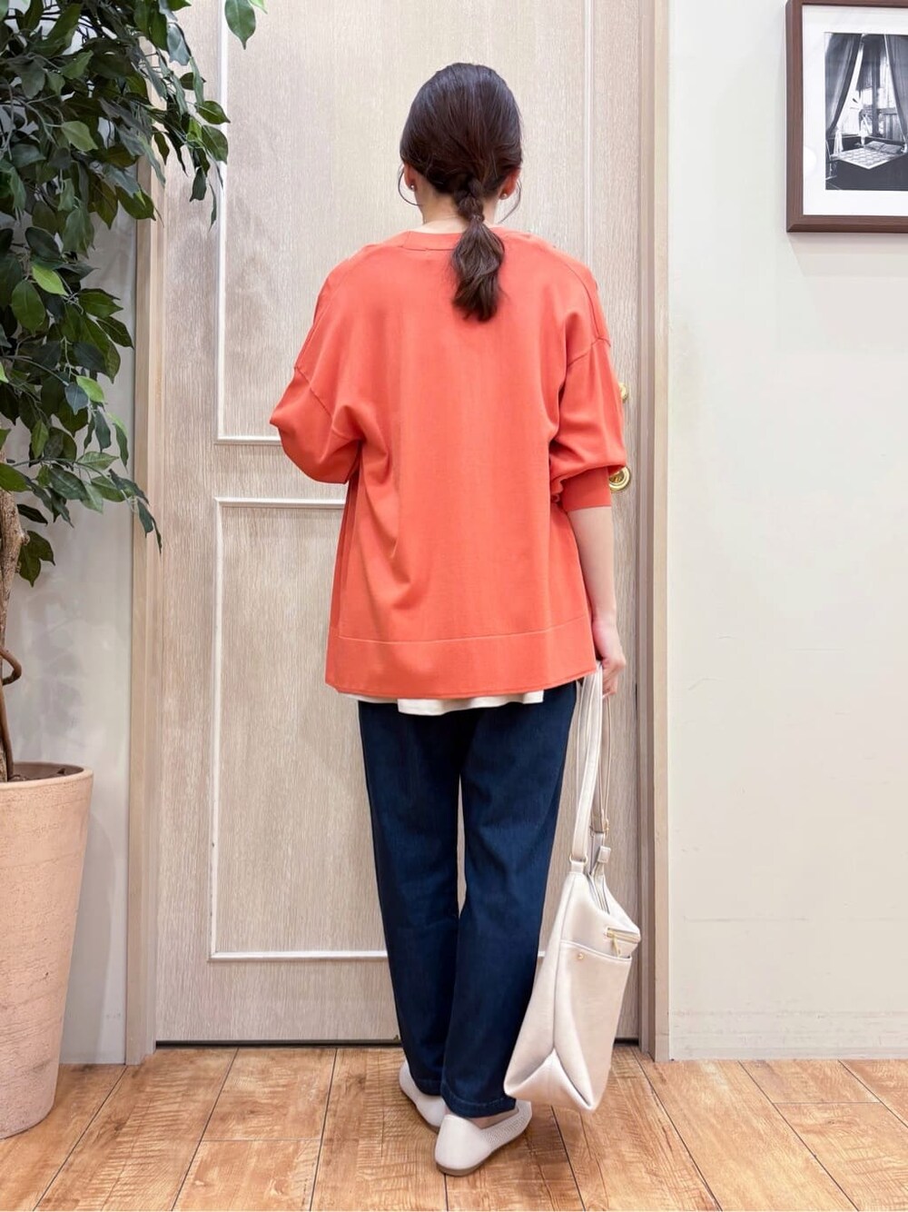 オレンジ系のカーディガン/ボレロ、ベージュ系のTシャツ/カットソー、ブルー系のその他パンツを着用したレディースの春コーディネートの3枚目の写真