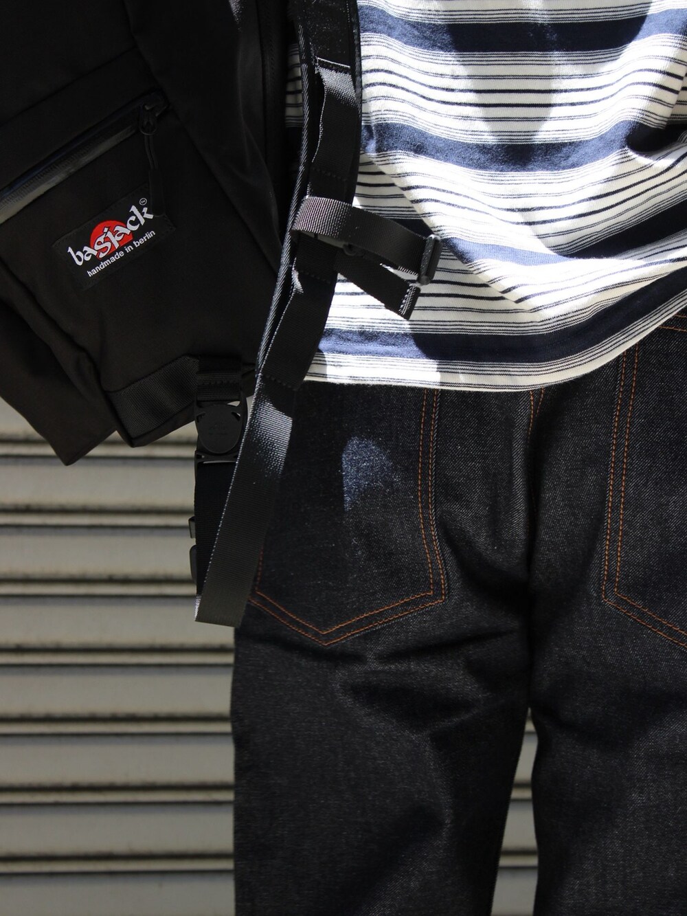 ブルー系のデニムパンツ、ブルー系のTシャツ/カットソー、ブラック系のバックパック/リュックを着用したメンズの夏コーディネートの7枚目の写真