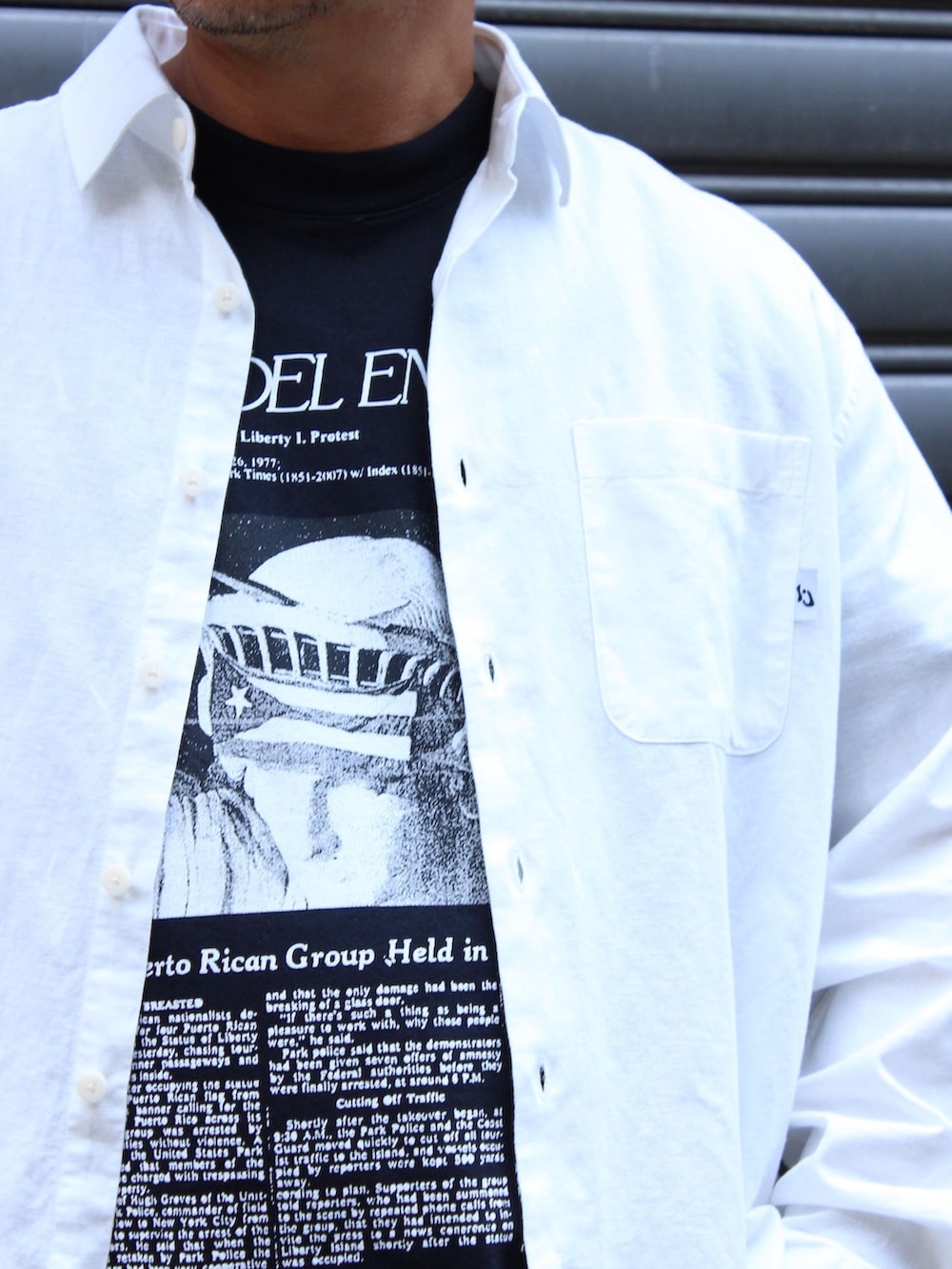 ブルー系のデニムパンツ、ホワイト系のシャツ/ブラウス、ブラック系のTシャツ/カットソーを着用したメンズの夏コーディネートの4枚目の写真