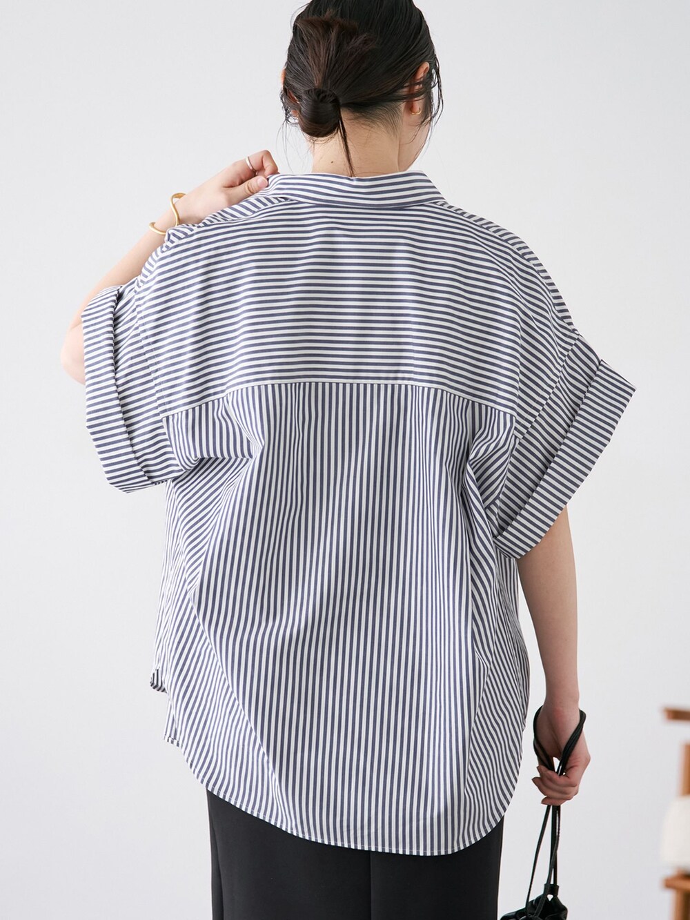 ブルー系のシャツ/ブラウス、ブラック系のスカート、ブラウン系のサンダルを着用したレディースの春コーディネートの6枚目の写真