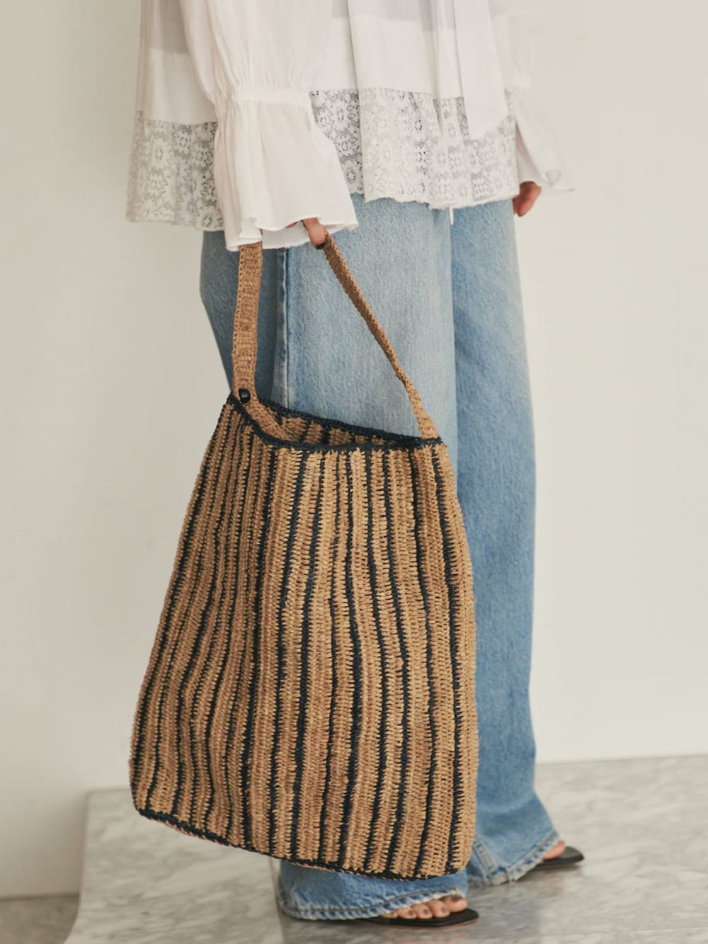 ブルー系のデニムパンツ、ホワイト系のシャツ/ブラウス、ブラウン系のサンダルを着用したレディースの夏コーディネートの10枚目の写真