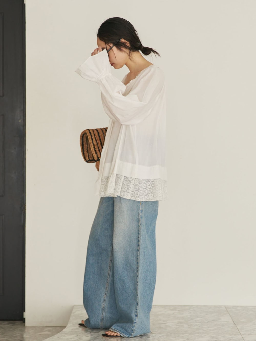 ブルー系のデニムパンツ、ホワイト系のシャツ/ブラウス、ブラウン系のサンダルを着用したレディースの夏コーディネートの2枚目の写真