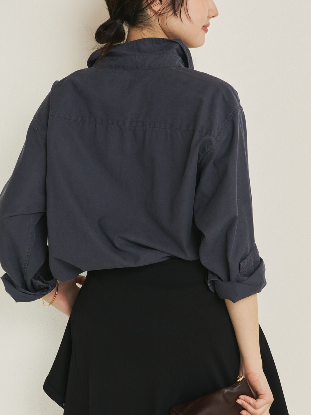 ブラック系のその他パンツ、ブルー系のシャツ/ブラウス、ブラウン系のクラッチバッグを着用したレディースの冬コーディネートの6枚目の写真