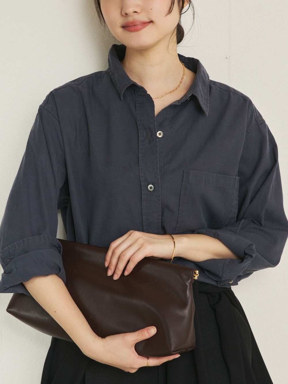 ブラック系のその他パンツ、ブルー系のシャツ/ブラウス、ブラウン系のクラッチバッグを着用したレディースの冬コーディネートの4枚目の写真