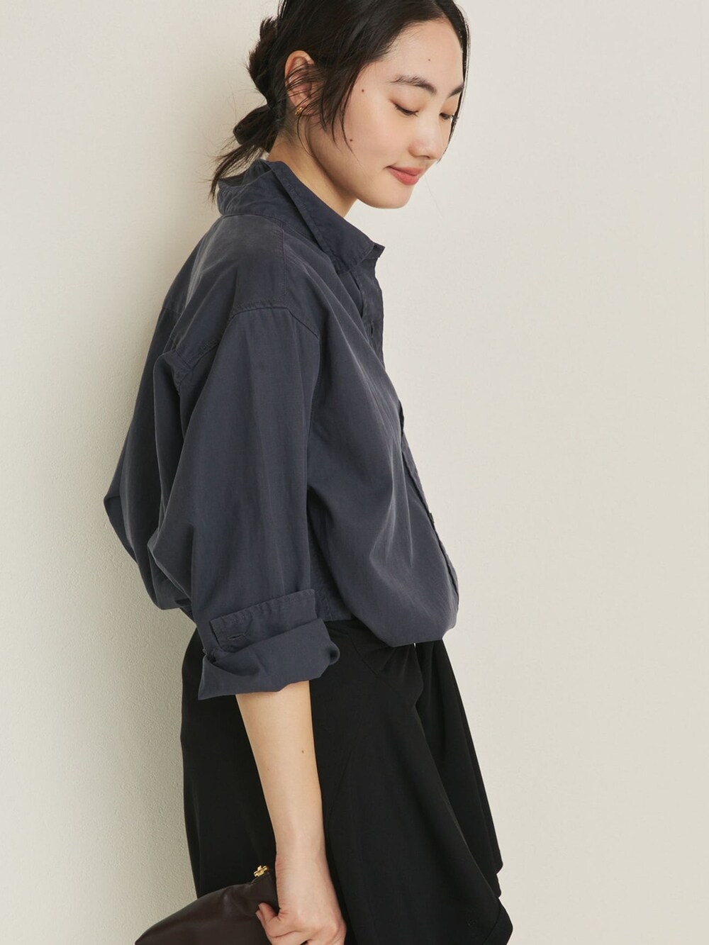 ブラック系のその他パンツ、ブルー系のシャツ/ブラウス、ブラウン系のクラッチバッグを着用したレディースの冬コーディネートの5枚目の写真