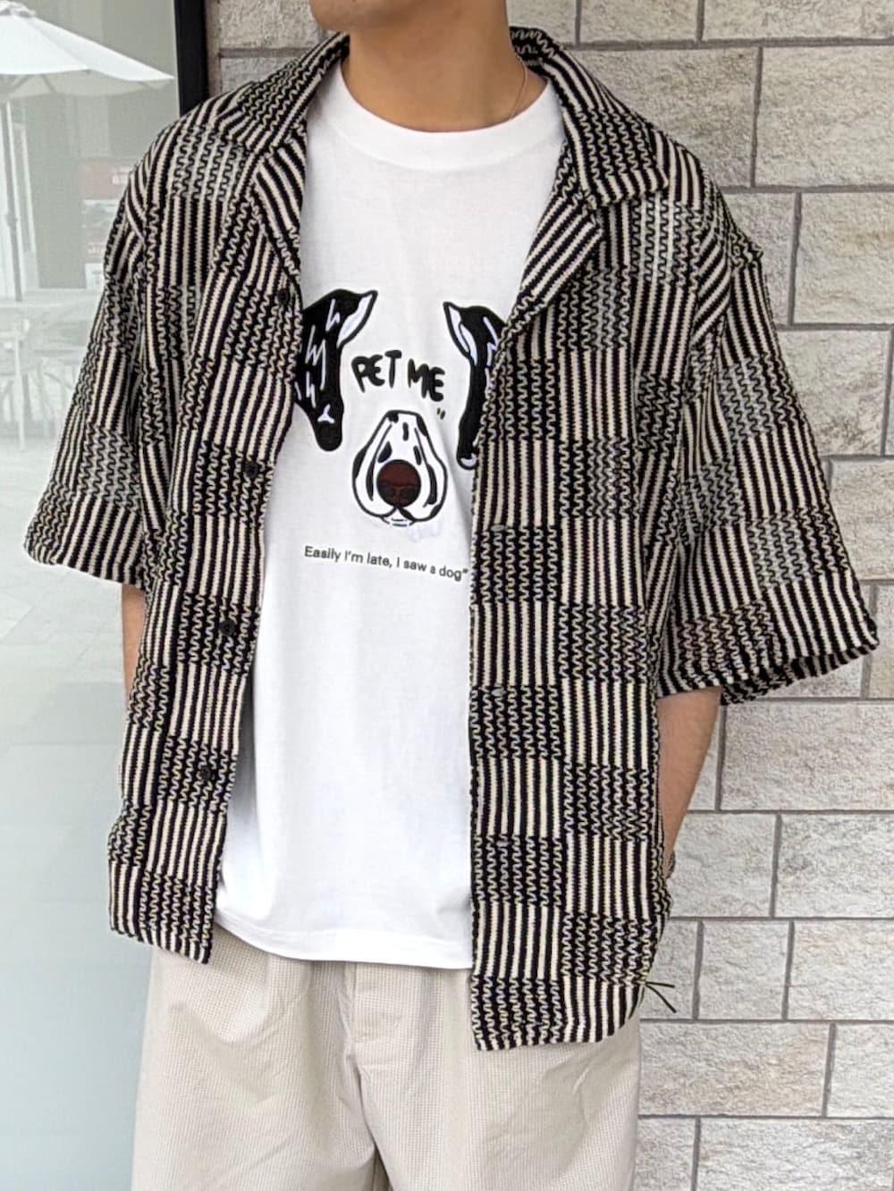ブラック系のスニーカー、ベージュ系のその他パンツ、ブラック系のシャツ/ブラウスを着用したメンズの春コーディネートの4枚目の写真