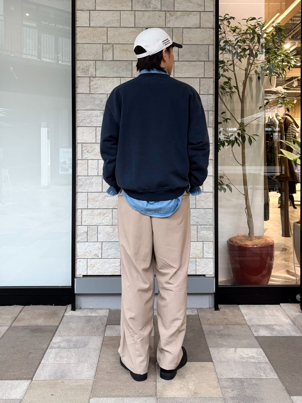 ブラック系のローファー、ブルー系のスウェット、ブルー系のキャップを着用したメンズの春コーディネートの3枚目の写真