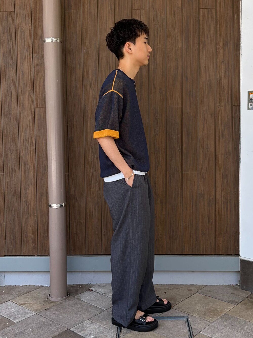 グレー系のその他パンツ、ホワイト系のTシャツ/カットソー、イエロー系のニット/セーターを着用したメンズの春コーディネートの2枚目の写真