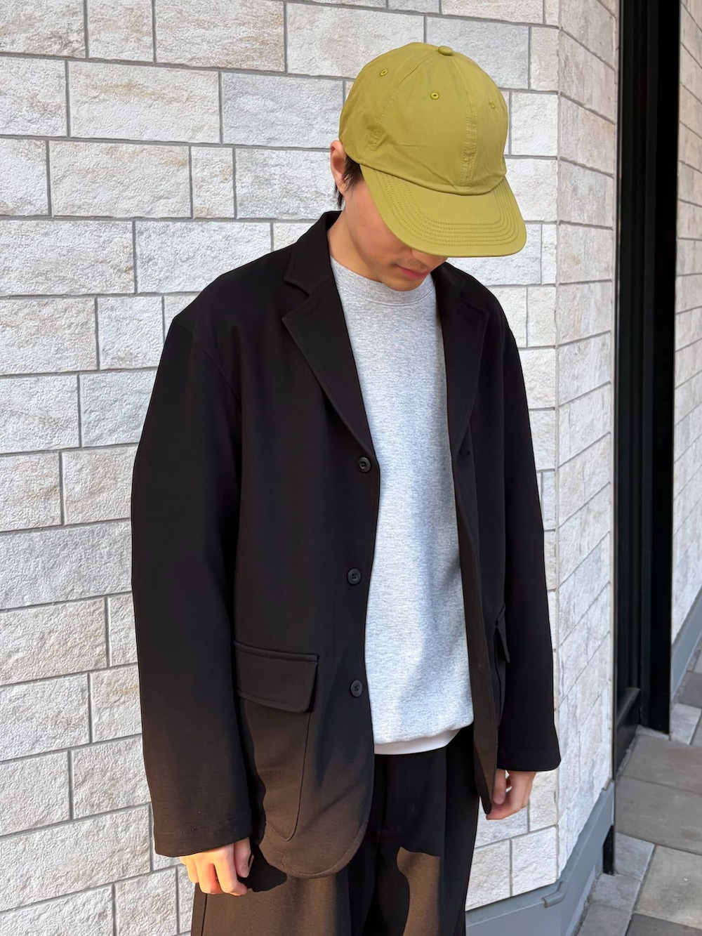 ブラック系のテーラードジャケット、ブラック系のその他パンツ、グレー系のスウェットを着用したメンズの春コーディネートの5枚目の写真