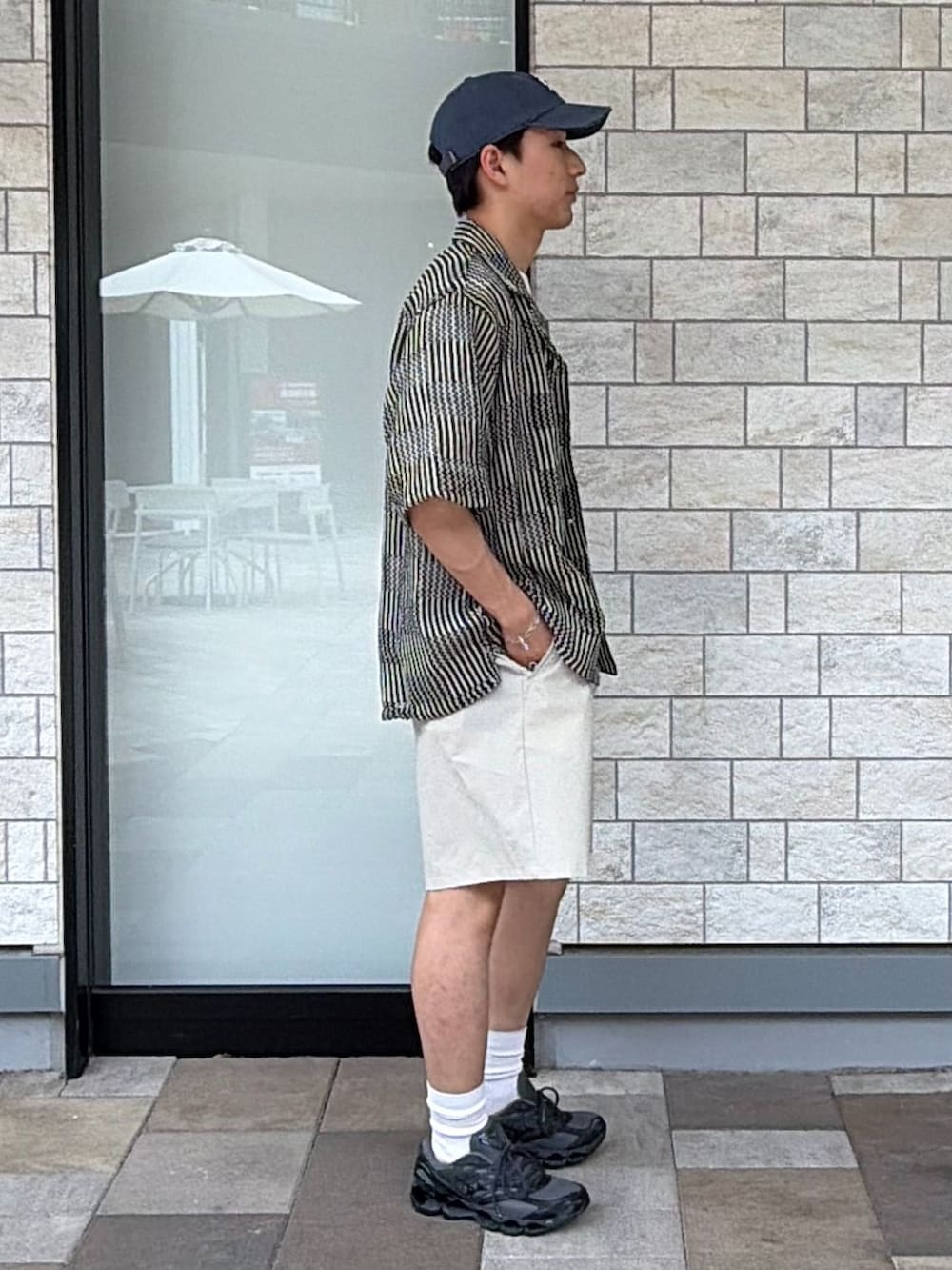 ブラック系のスニーカー、ベージュ系のその他パンツ、ブラック系のシャツ/ブラウスを着用したメンズの春コーディネートの2枚目の写真