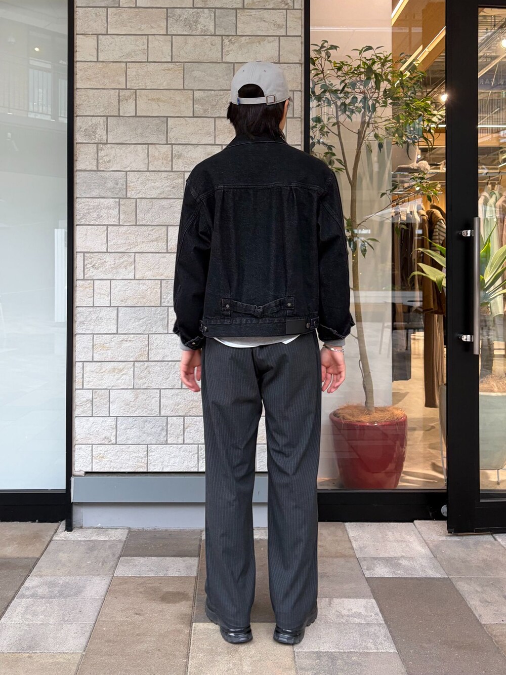 ブラック系のデニムジャケット、グレー系のその他パンツ、グレー系のキャップを着用したメンズの冬コーディネートの3枚目の写真