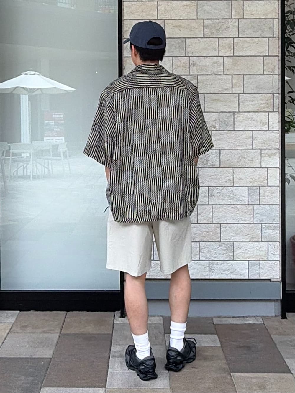 ブラック系のスニーカー、ベージュ系のその他パンツ、ブラック系のシャツ/ブラウスを着用したメンズの春コーディネートの3枚目の写真