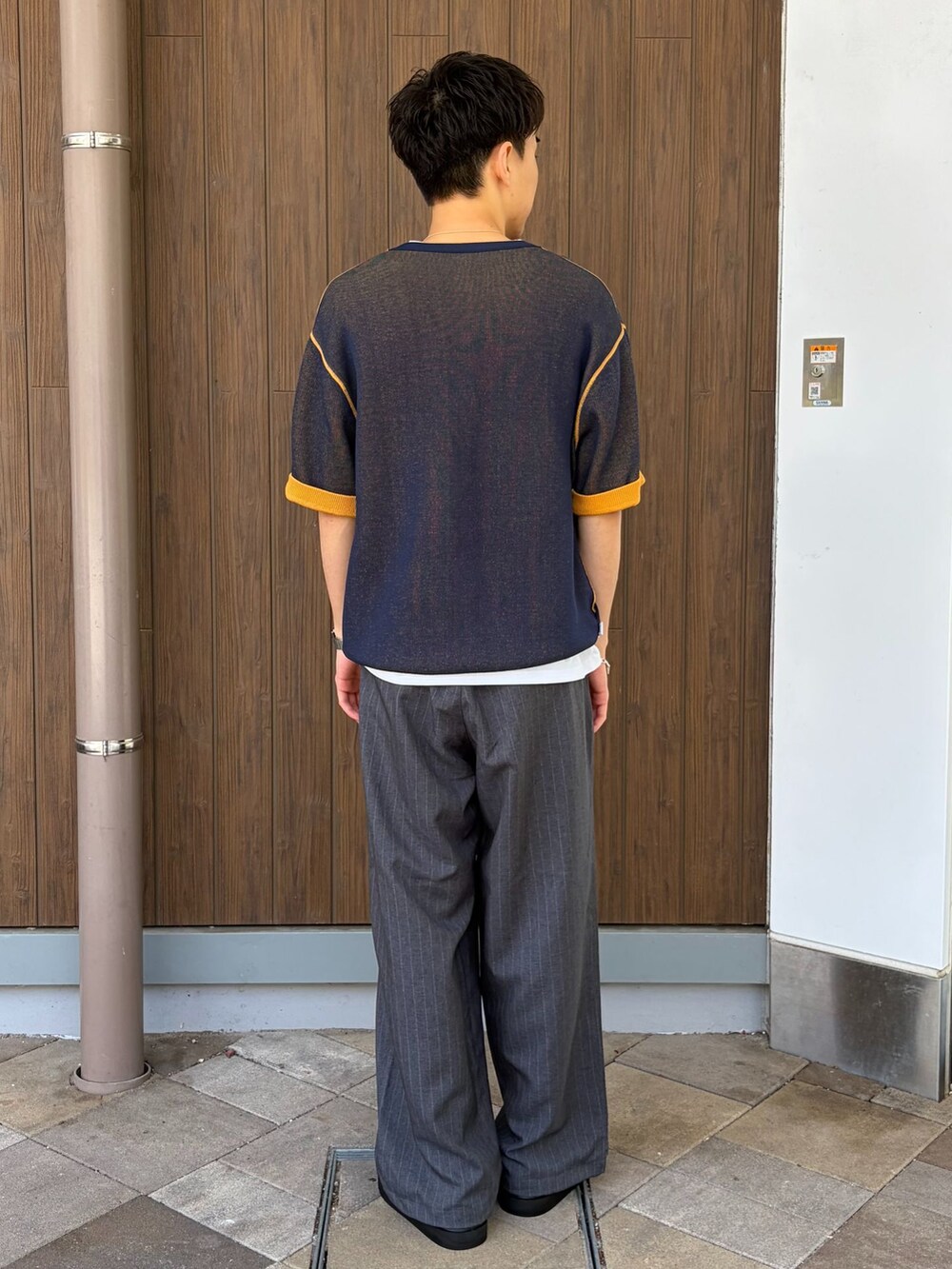 グレー系のその他パンツ、ホワイト系のTシャツ/カットソー、イエロー系のニット/セーターを着用したメンズの春コーディネートの3枚目の写真