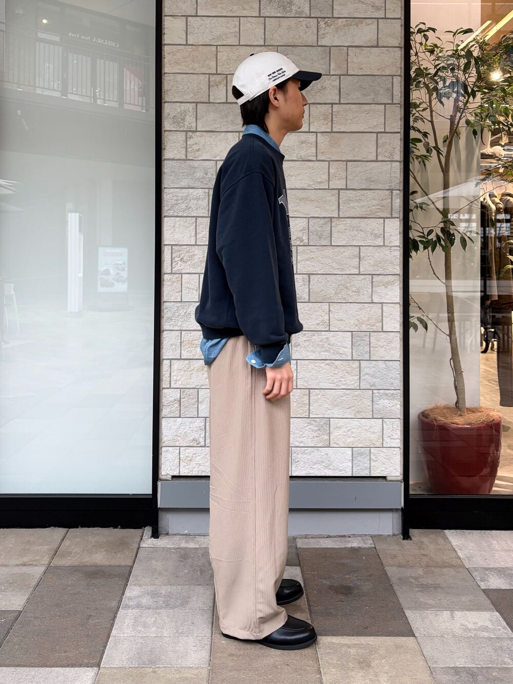 ブラック系のローファー、ブルー系のスウェット、ブルー系のキャップを着用したメンズの春コーディネートの2枚目の写真
