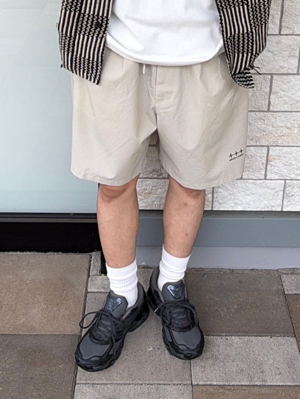ブラック系のスニーカー、ベージュ系のその他パンツ、ブラック系のシャツ/ブラウスを着用したメンズの春コーディネートの5枚目の写真