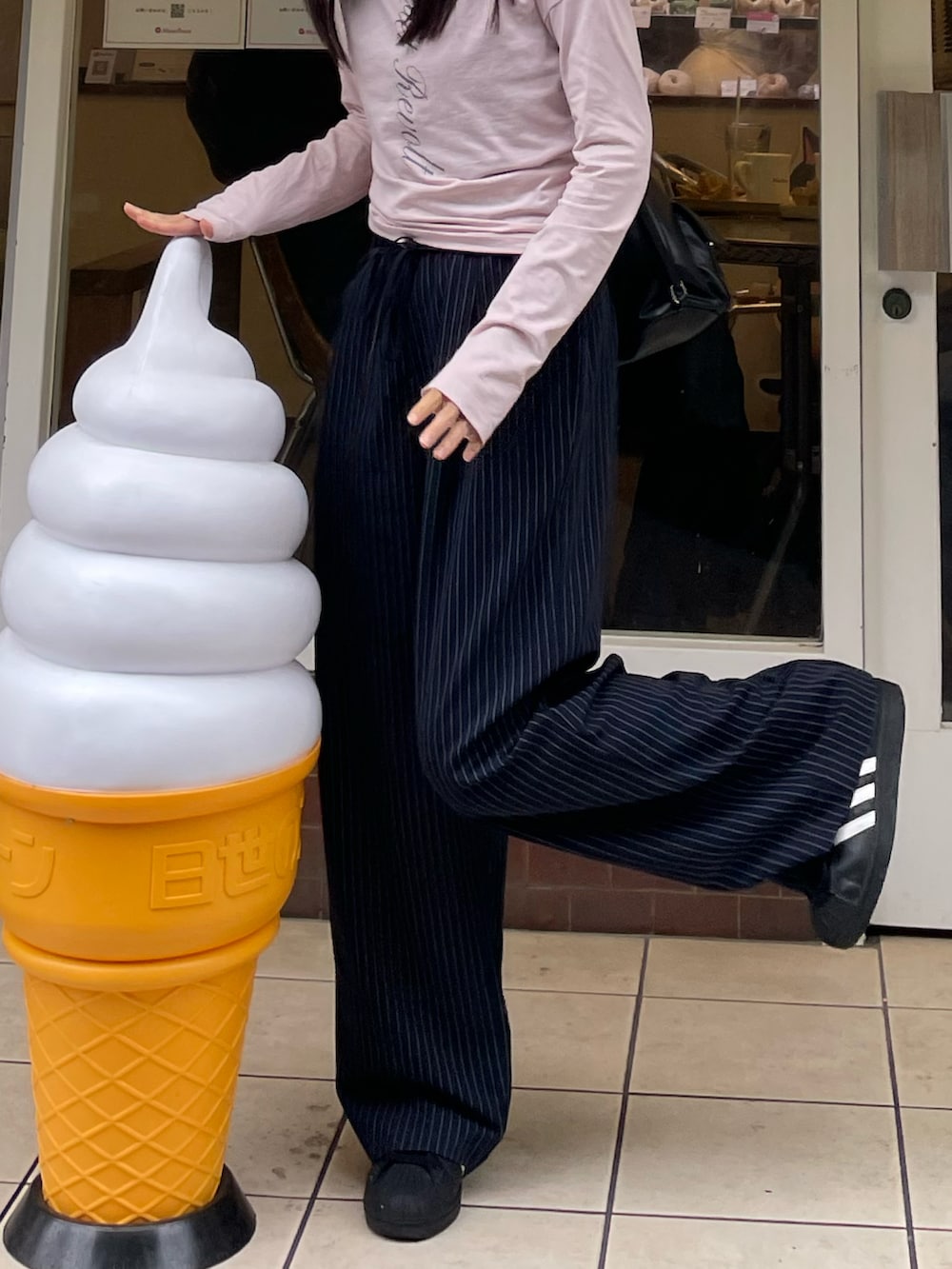 ピンク系のTシャツ/カットソー、ブルー系のスラックスを着用したレディースの夏コーディネートの2枚目の写真