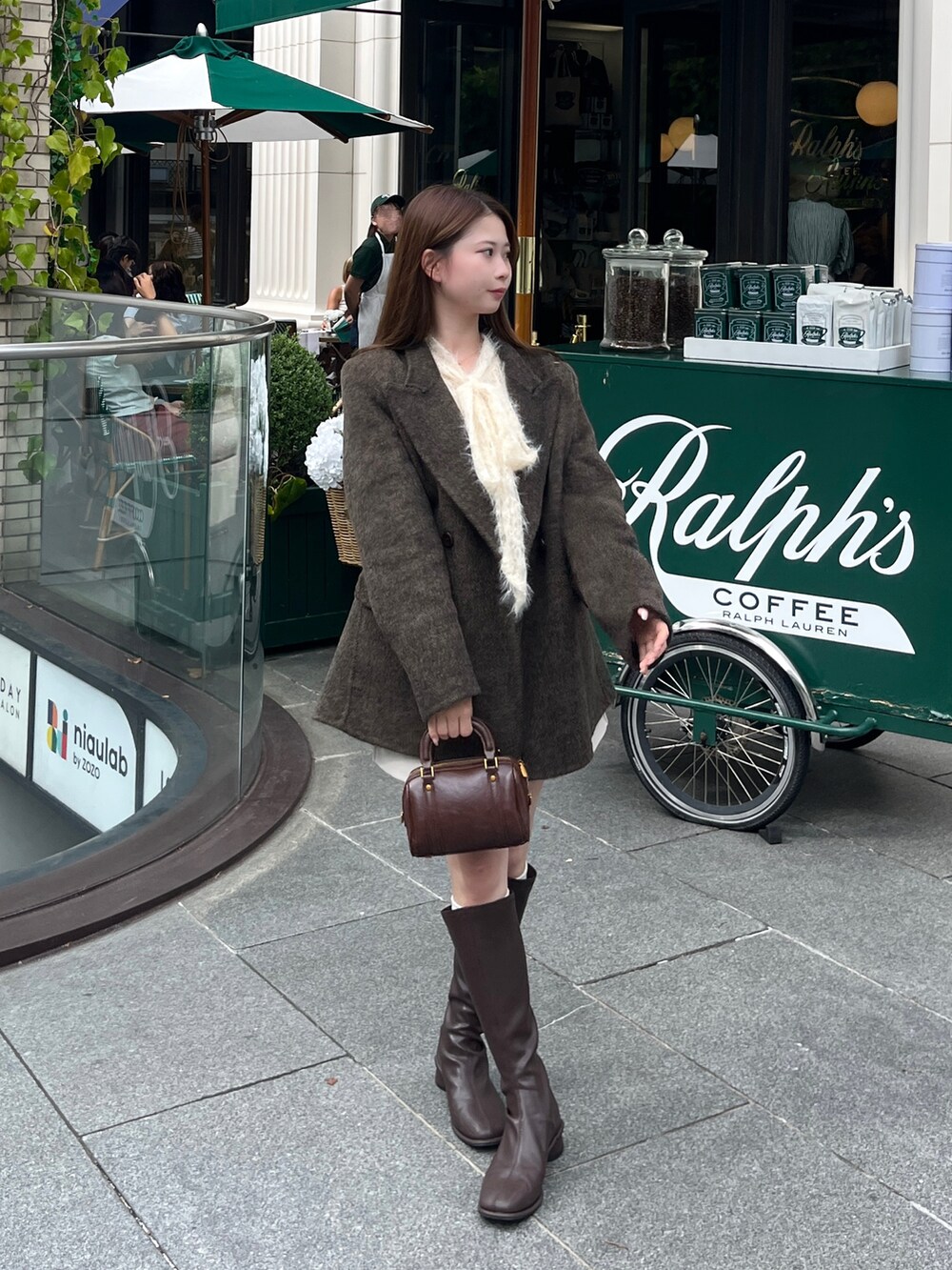 ホワイト系のシャツ/ブラウス、ブラウン系のボストンバッグ、ブラウン系のテーラードジャケットを着用したレディースの秋コーディネートの2枚目の写真