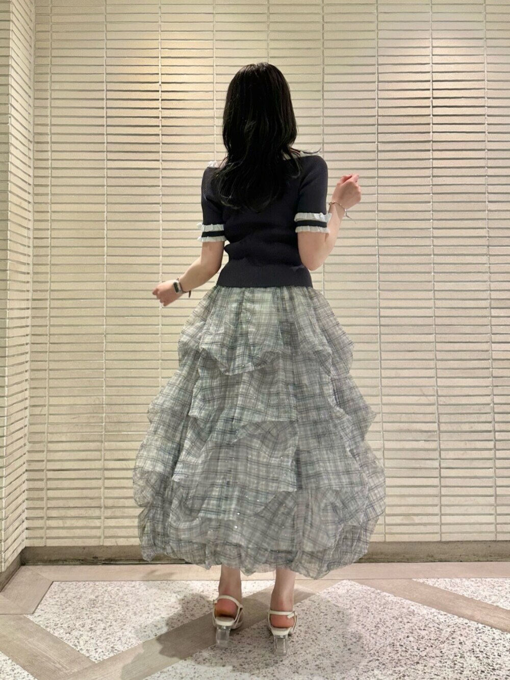 グレー系のニット/セーター、ブルー系のスカート、ホワイト系のサンダルを着用したレディースの夏コーディネートの4枚目の写真
