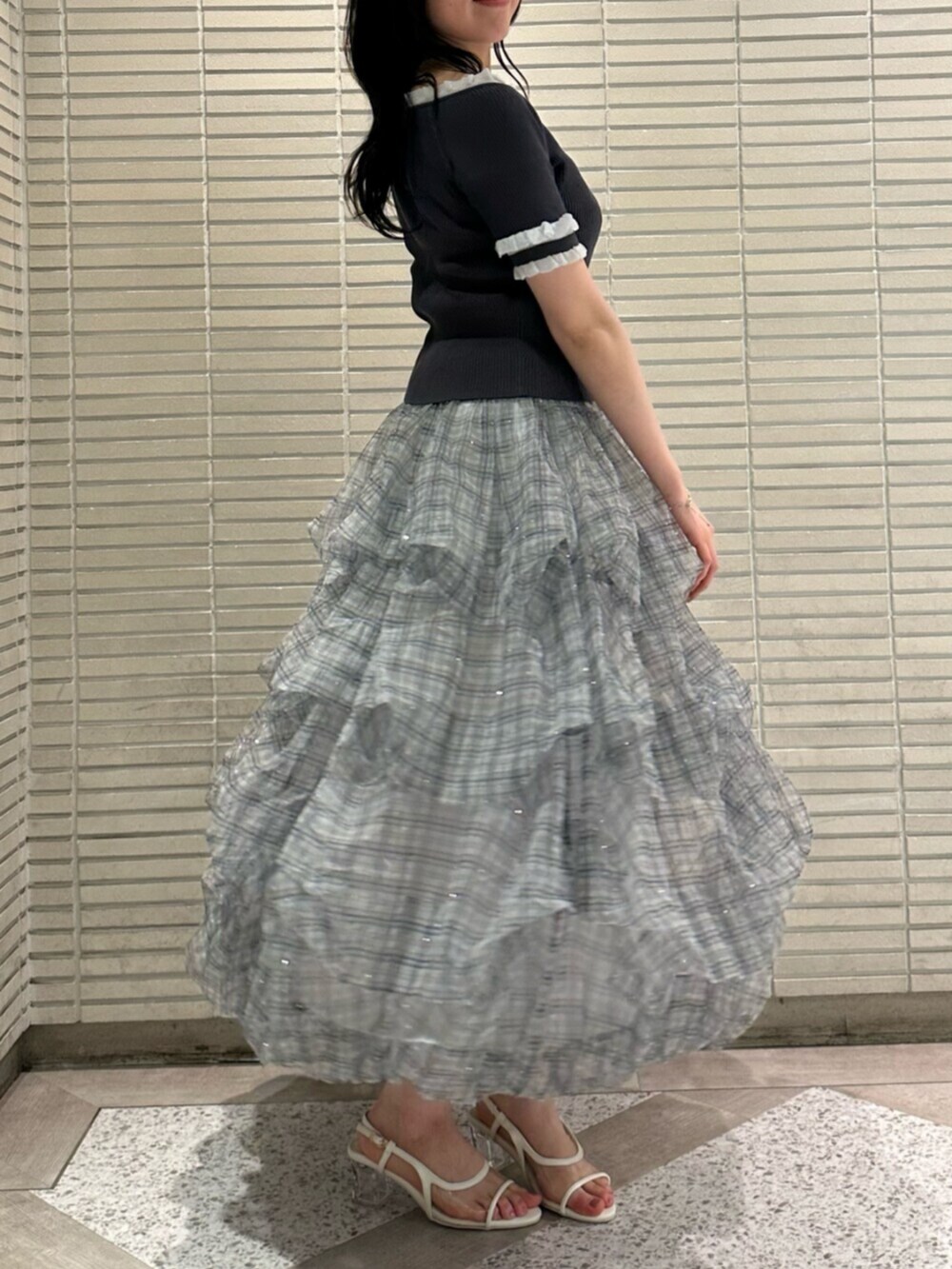 グレー系のニット/セーター、ブルー系のスカート、ホワイト系のサンダルを着用したレディースの夏コーディネートの5枚目の写真