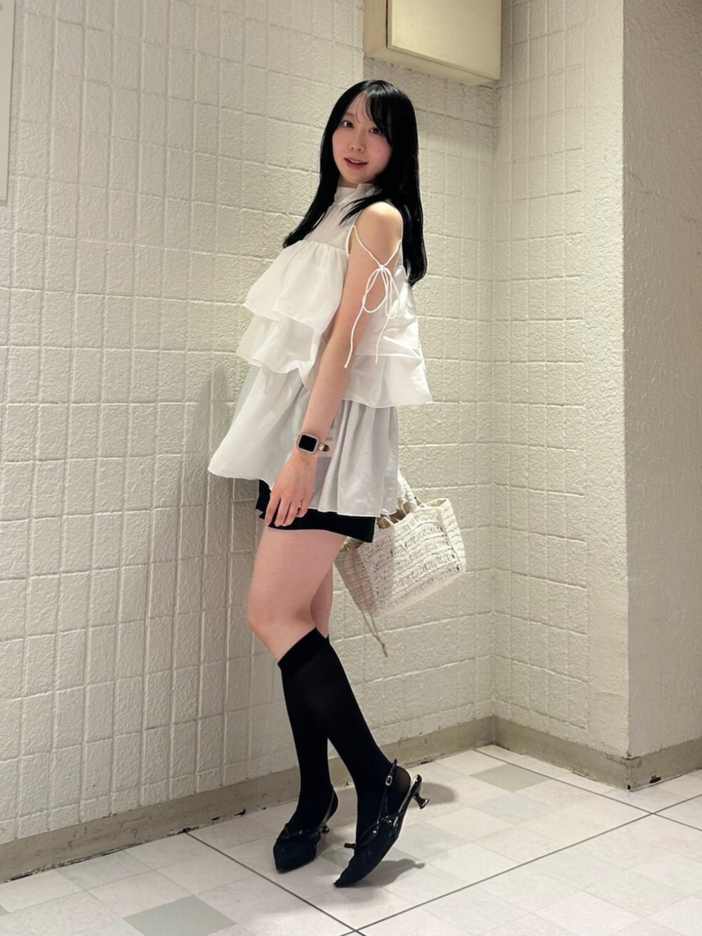 ホワイト系のシャツ/ブラウス、ブラック系のパンプス、ホワイト系のかごバッグを着用したレディースの夏コーディネートの3枚目の写真