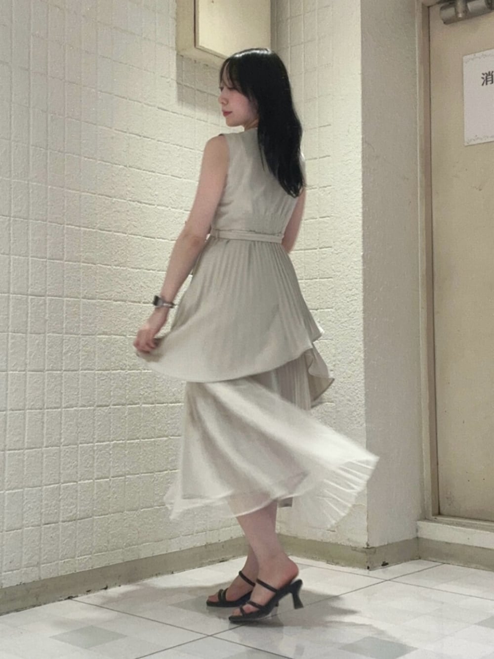 ベージュ系のワンピース、ブラック系のサンダルを着用したレディースの夏コーディネートの2枚目の写真