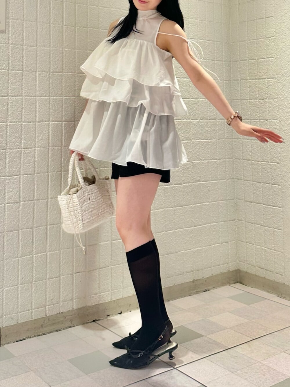ホワイト系のシャツ/ブラウス、ブラック系のパンプス、ホワイト系のかごバッグを着用したレディースの夏コーディネートの5枚目の写真