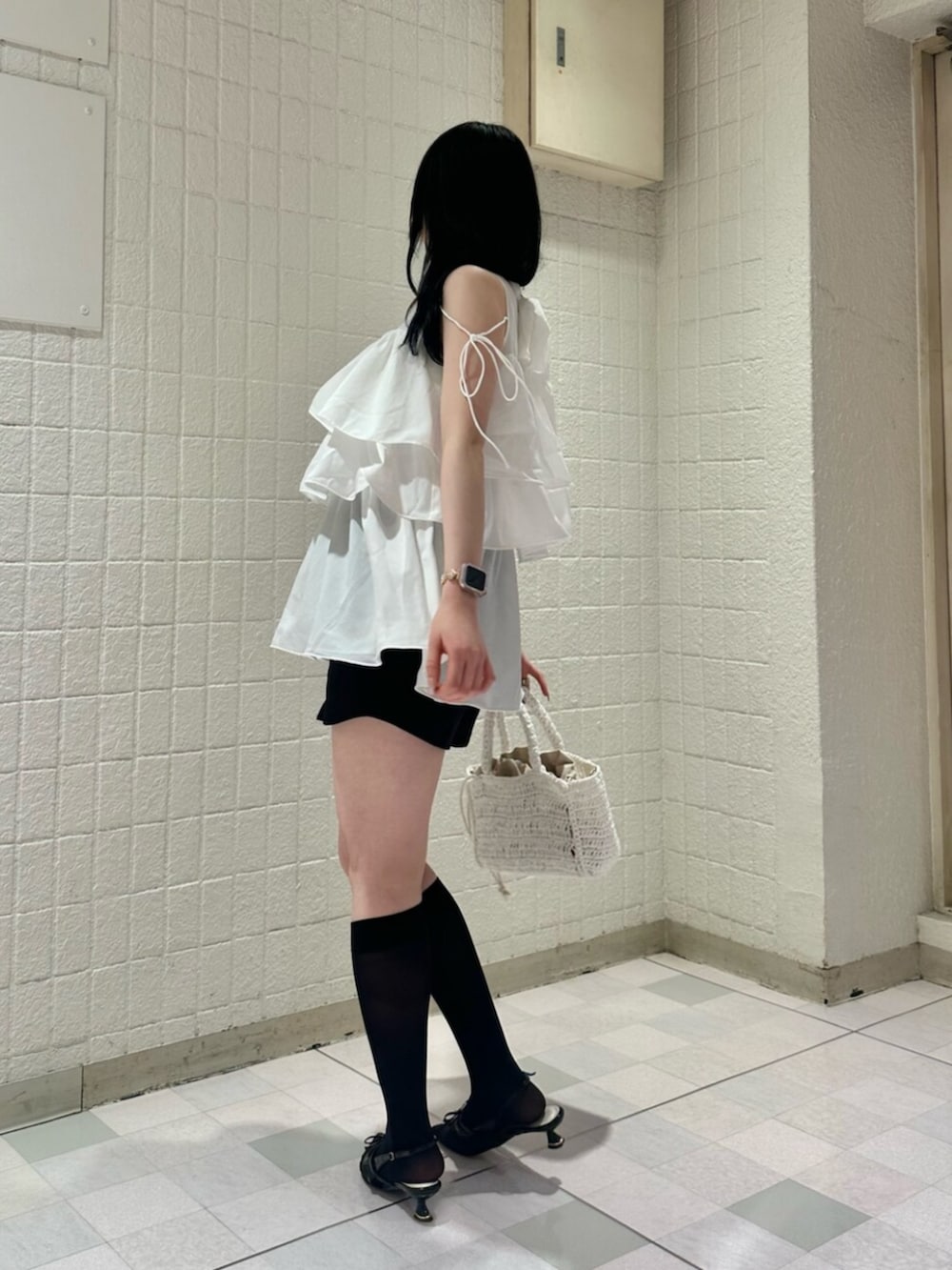 ホワイト系のシャツ/ブラウス、ブラック系のパンプス、ホワイト系のかごバッグを着用したレディースの夏コーディネートの2枚目の写真
