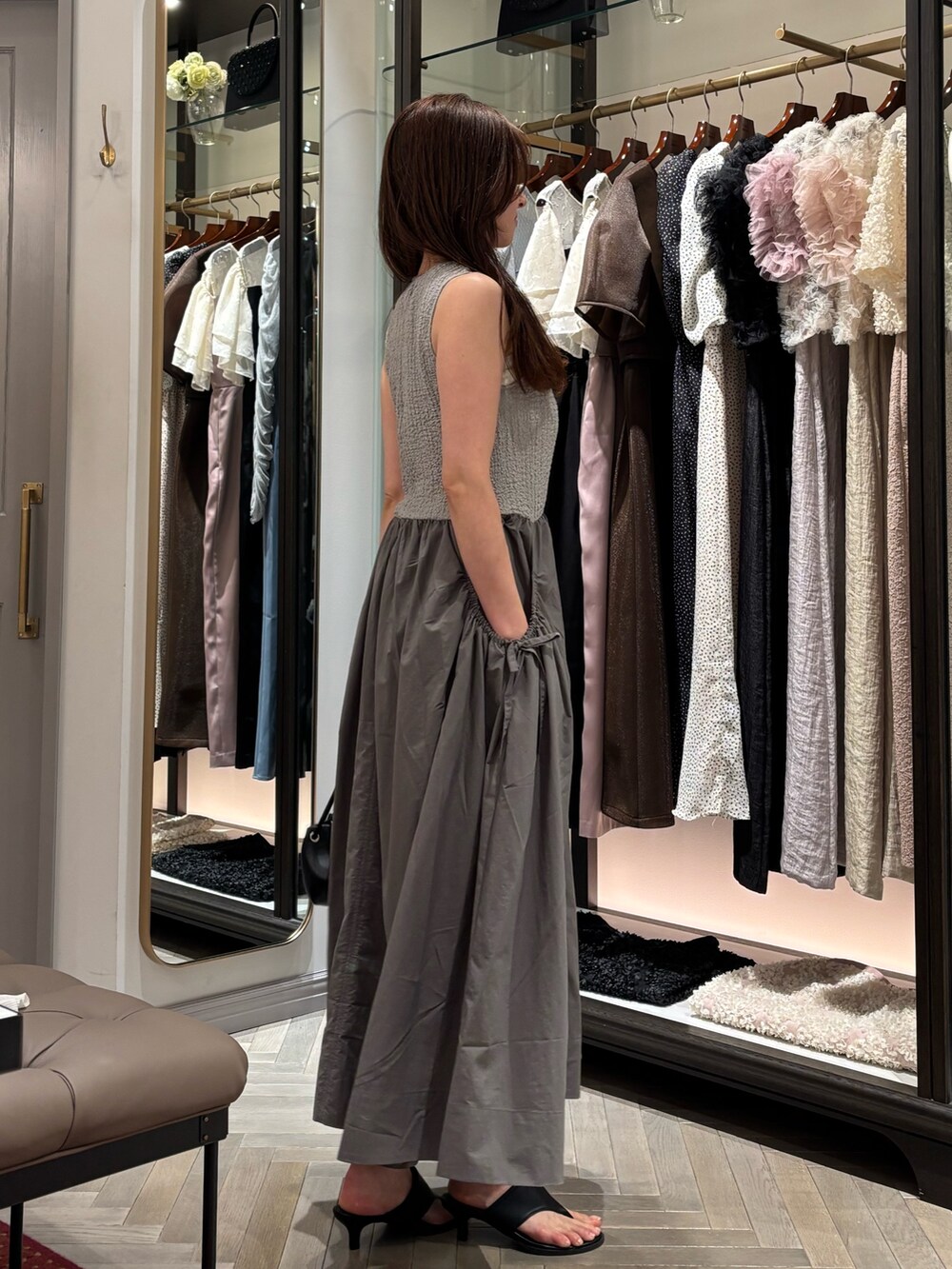 グレー系のワンピース、ブラック系のショルダーバッグ、ブラック系のサンダルを着用したレディースの夏コーディネートの4枚目の写真