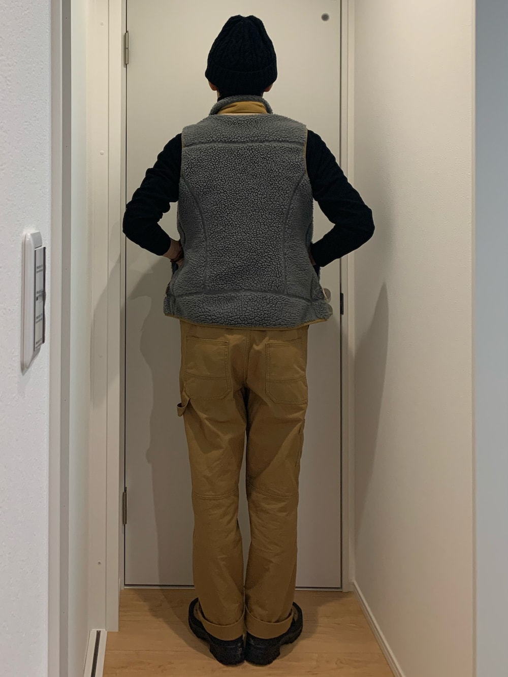 ブラウン系のサロペット/オーバーオール、グレー系のベスト、ブラウン系のブーツを着用したメンズの冬コーディネートの3枚目の写真