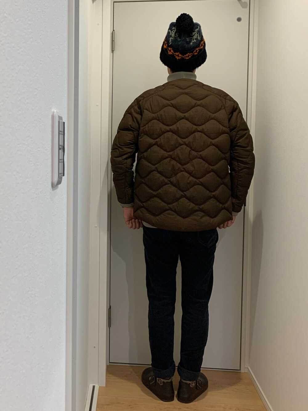 ベージュ系のスウェット、ブラック系のダウンベスト、ブラック系のその他パンツを着用したメンズの冬コーディネートの3枚目の写真