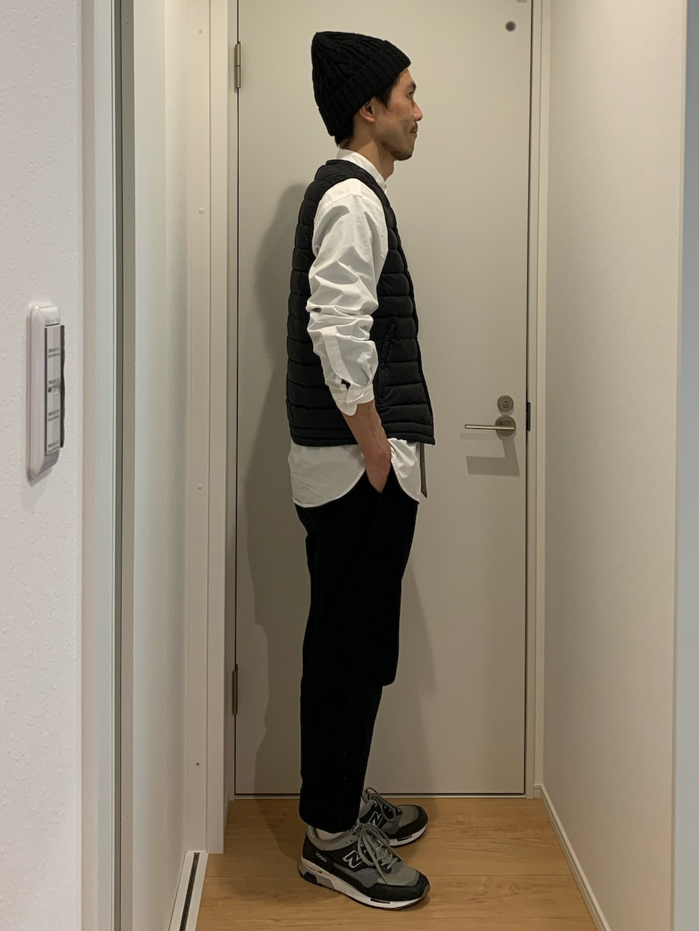 ブラック系のダウンベスト、ホワイト系のシャツ/ブラウス、ブラック系のその他パンツを着用したメンズの春コーディネートの2枚目の写真