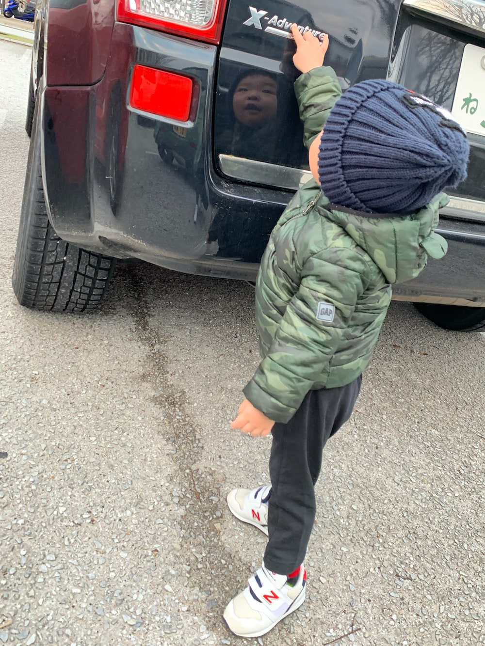 グリーン系のダウンジャケット/コート、ホワイト系のスニーカー、ブルー系のニットキャップ/ビーニーを着用したメンズの冬コーディネートの2枚目の写真