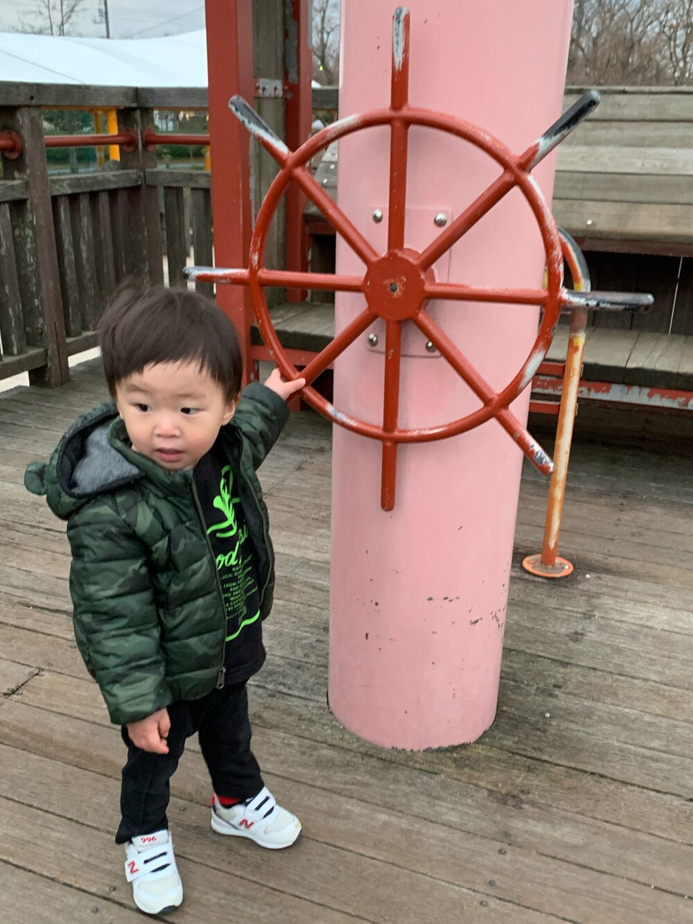 グリーン系のダウンジャケット/コート、ホワイト系のスニーカー、ブルー系のニットキャップ/ビーニーを着用したメンズの冬コーディネートの3枚目の写真