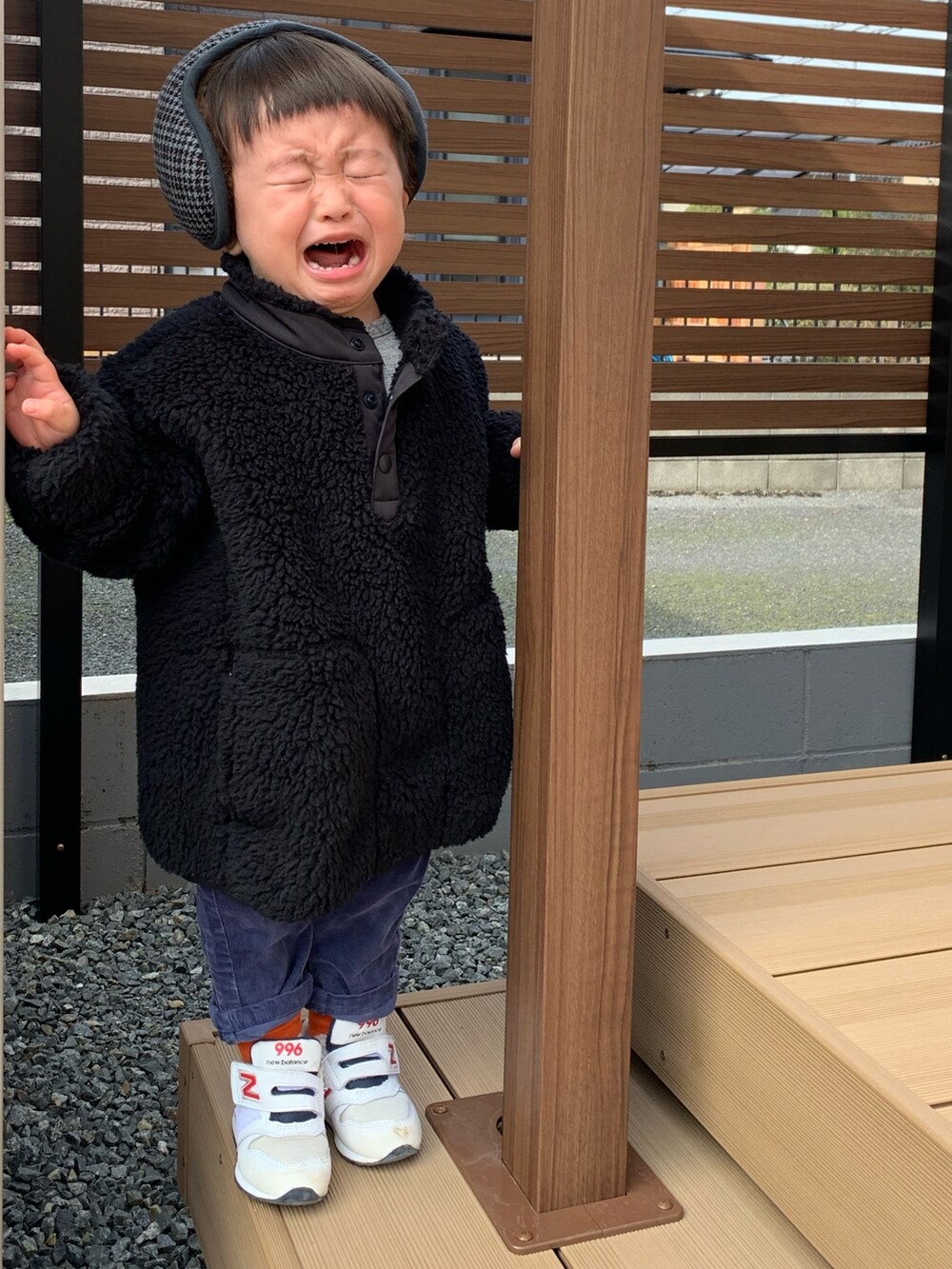 ブラック系のトップス、ホワイト系のスニーカー、グレー系のイヤーマフを着用したメンズの冬コーディネートの5枚目の写真