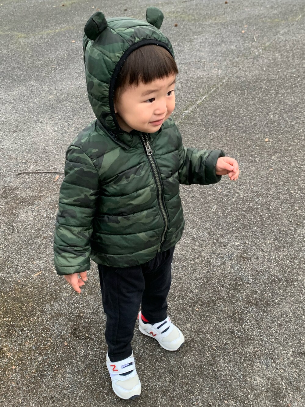 グリーン系のダウンジャケット/コート、ホワイト系のスニーカー、ブルー系のニットキャップ/ビーニーを着用したメンズの冬コーディネートの4枚目の写真