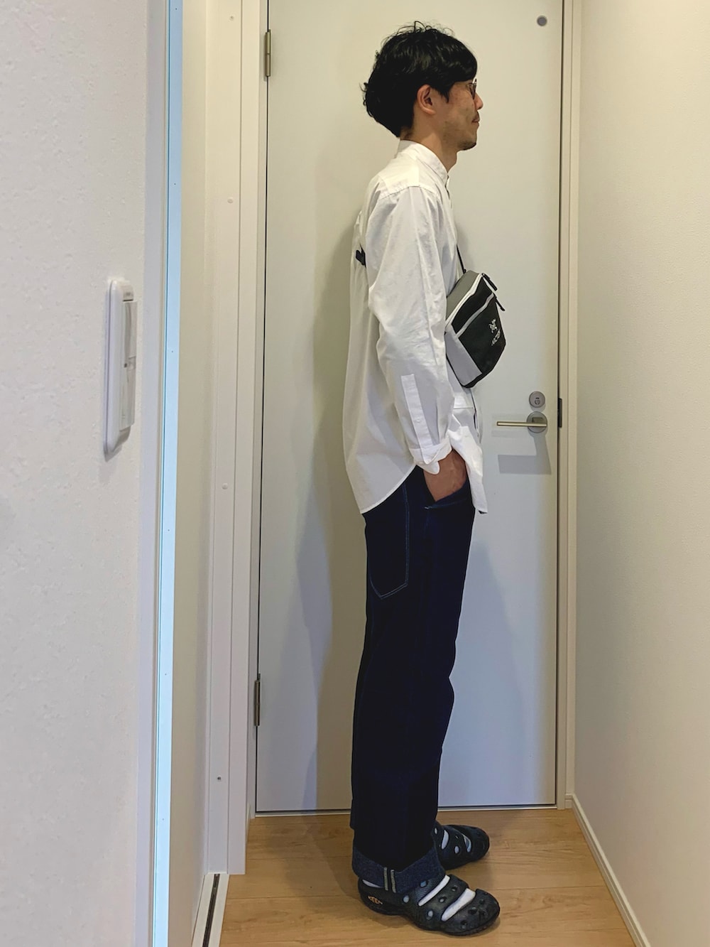 ベージュ系のステンカラーコート、ホワイト系のシャツ/ブラウス、グレー系のショルダーバッグを着用したメンズの春コーディネートの5枚目の写真