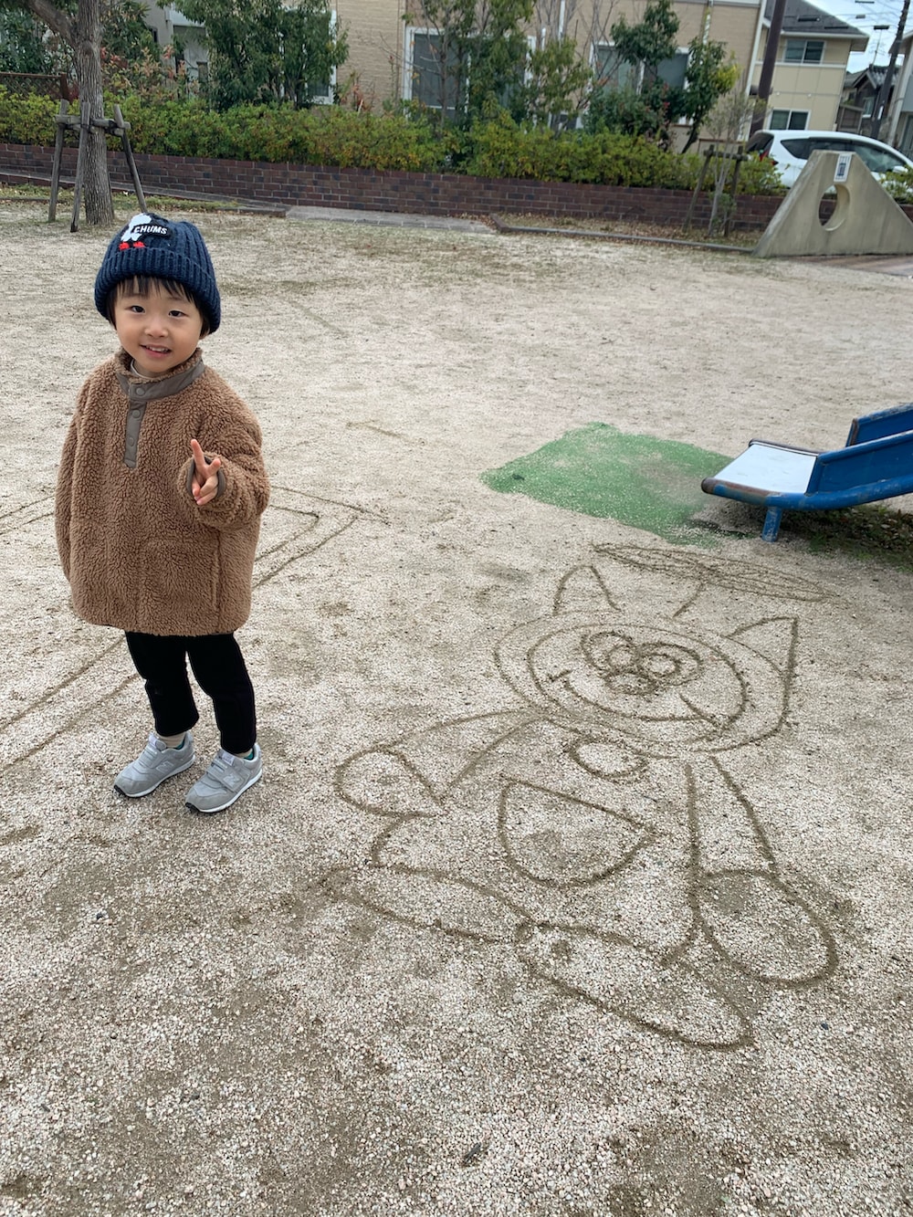 ブラウン系のジャケット/アウター、グレー系のスニーカー、ブルー系のニットキャップ/ビーニーを着用したメンズの冬コーディネートの4枚目の写真