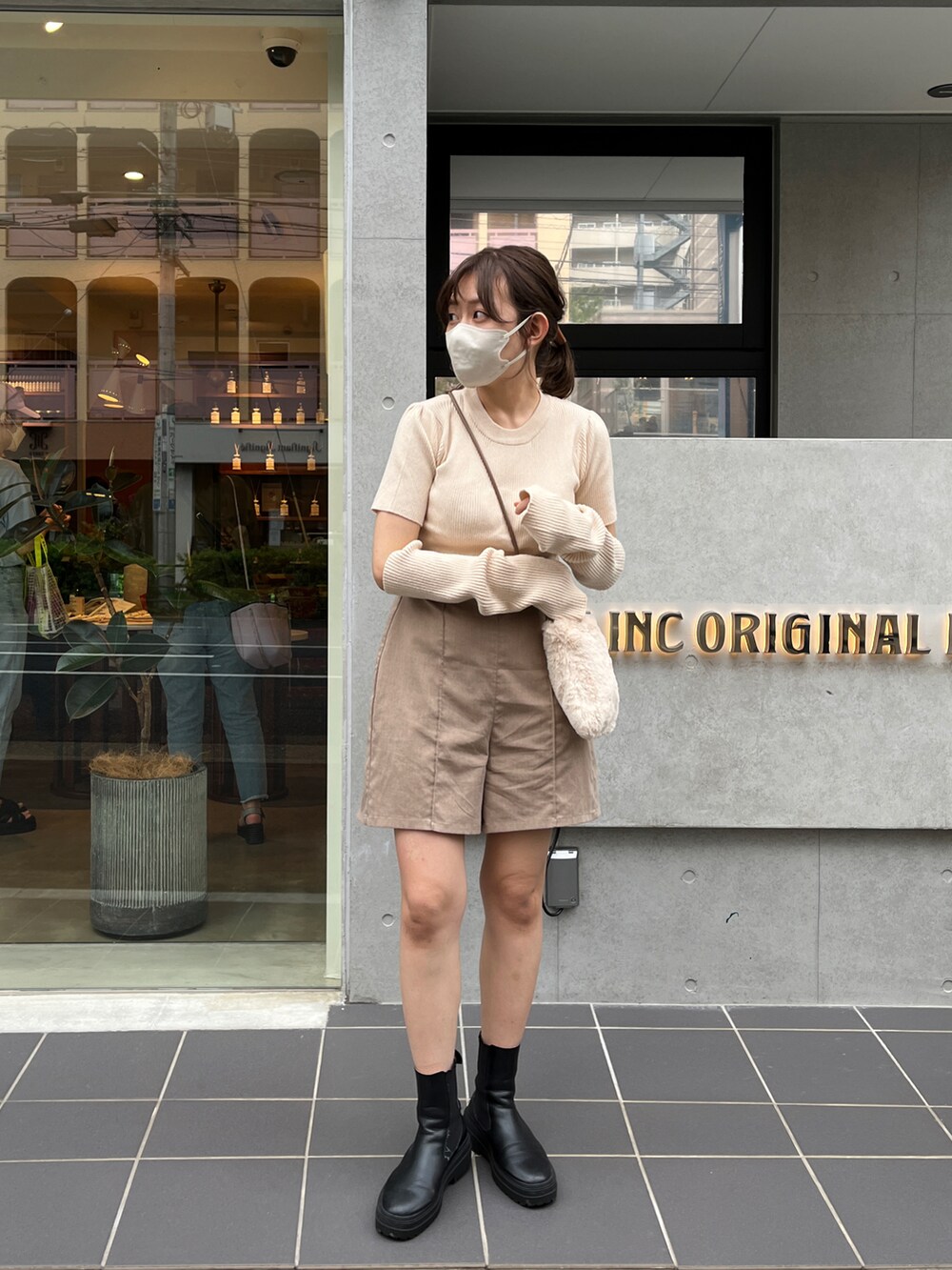 ホワイト系のニット/セーター、ブルー系のその他パンツ、ブラック系のブーツを着用したレディースの秋コーディネートの2枚目の写真